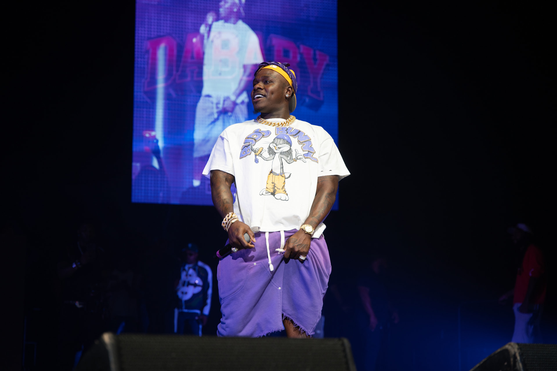 DaBaby smiling under the DABABY LED backdrop
